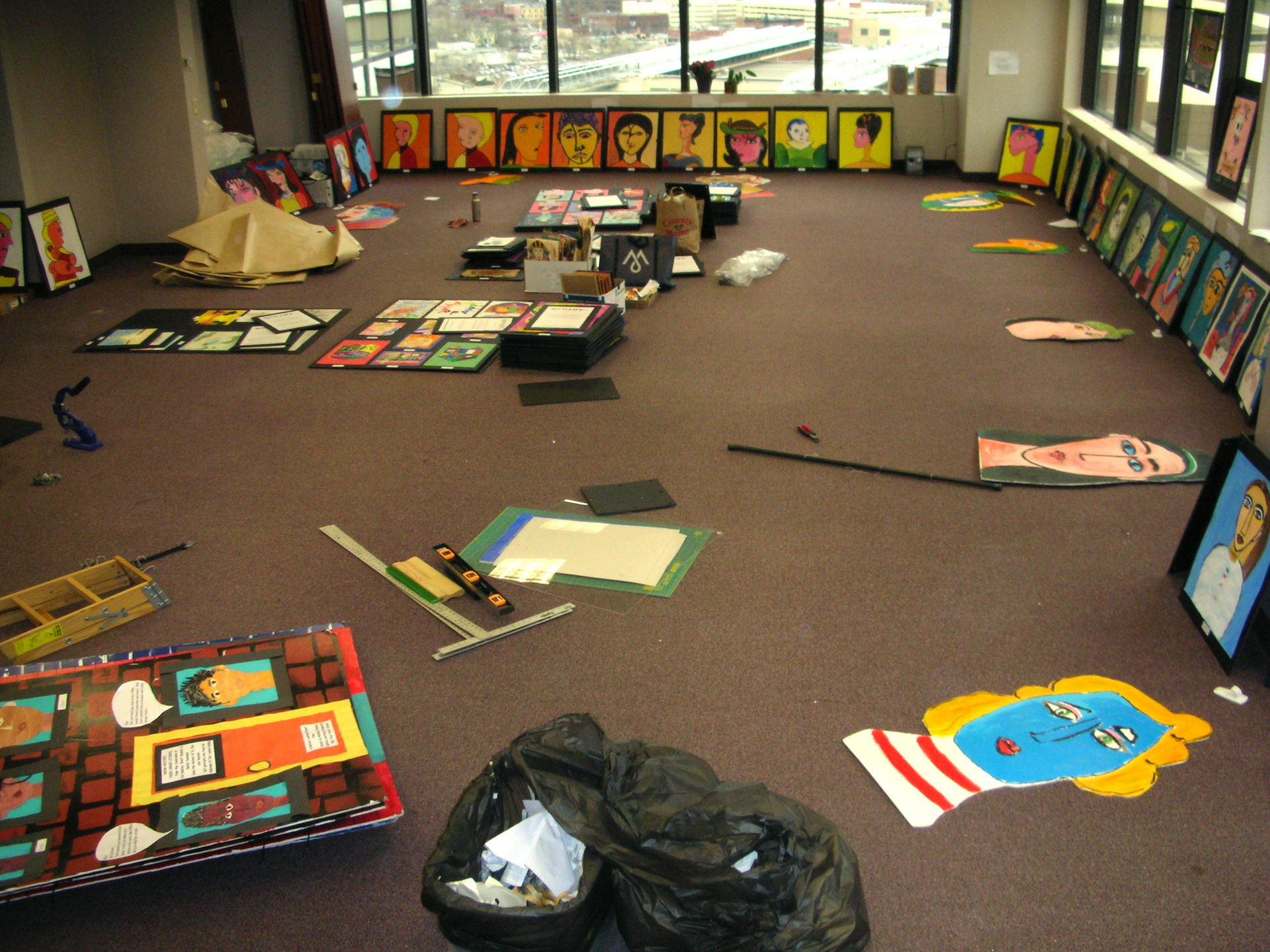 A workspace scattered with tools and children's art